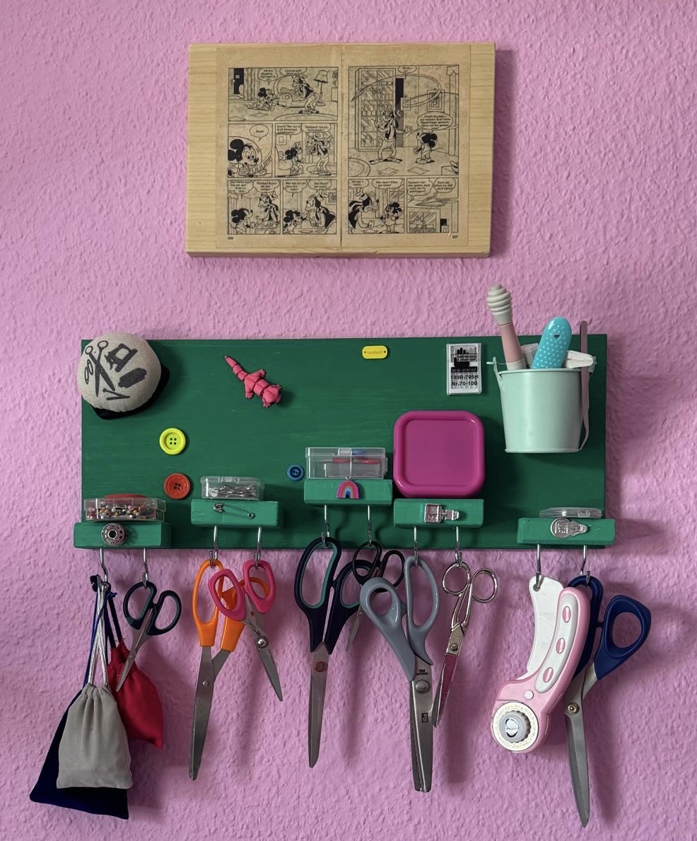 Grünes Nähutensilien-Board mit Scheren und Comic-Bildtafel